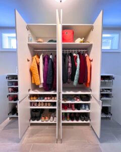 Photo of a wardrobe with the doors open, showing colorful organized coats, shoes, and accessories.